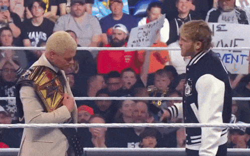 two men in a wrestling ring with one wearing a jacket that says " ufc "