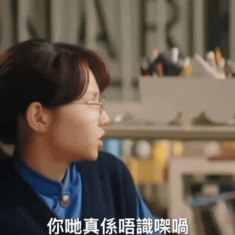 a woman wearing glasses and a blue shirt has chinese writing on her chest