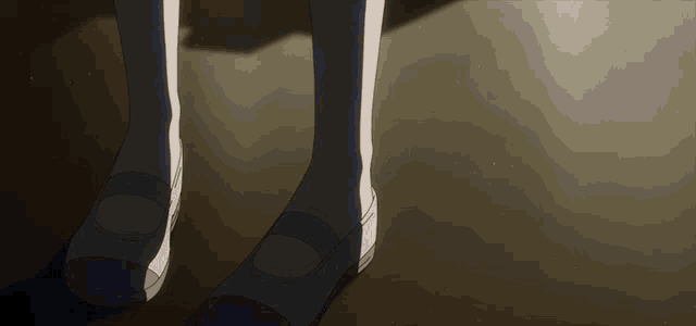 a close up of a person 's feet with black shoes
