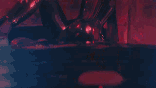 a woman in a corset and black pants is sitting in a dark room