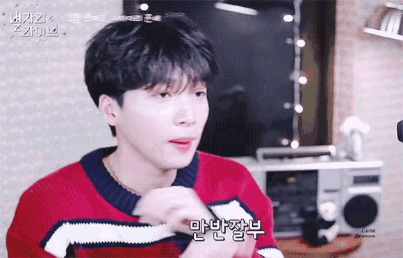 a young man wearing a red and white sweater is talking to someone