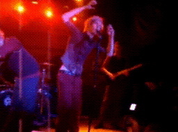 a blurry photo of a band on stage with a drummer and a guitar player