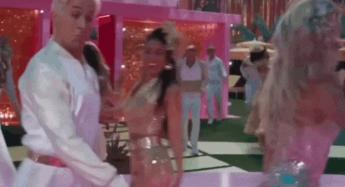 a man and a woman are dancing on a dance floor in a pink room .