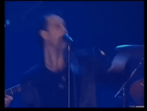 a man is singing into a microphone on stage .