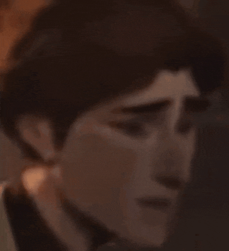 a close up of a man 's face with a sad expression .