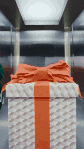 a white gift box with an orange bow on it