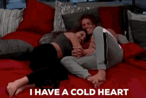 a man and a woman hugging on a bed with the words " i have a cold heart " above them