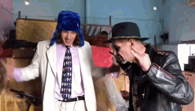 two men wearing hats and ties are dancing together