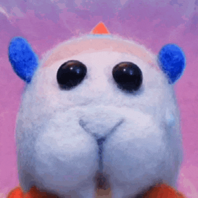 a close up of a stuffed animal 's face with big eyes and a purple background .