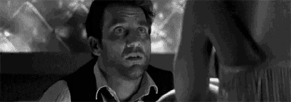 a man in a suit and tie is looking at a woman .
