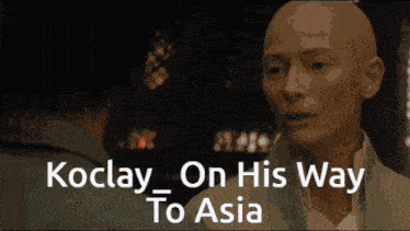 a man with a beard is being touched by another man with the words " koclay on his way to asia " below him