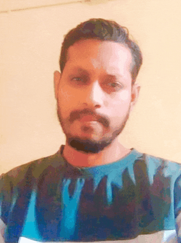 a man with a beard and mustache is wearing a blue and black shirt