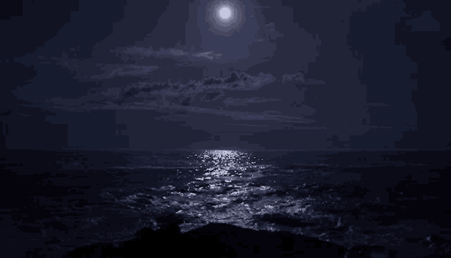 a full moon is reflected in the ocean at night