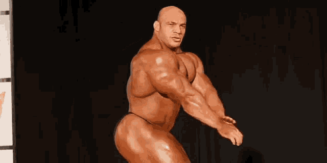 a bodybuilder is posing for a picture on a stage .