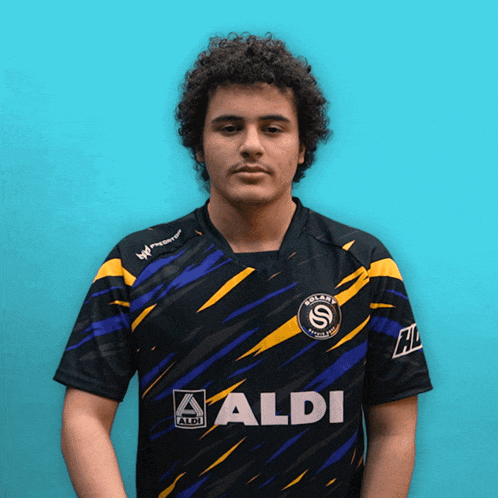a man wearing a black and yellow shirt that says aldi on the front