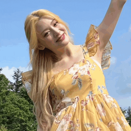a woman in a yellow floral dress with ruffled sleeves