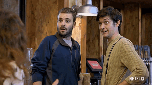 two men standing next to each other with a netflix logo on the bottom