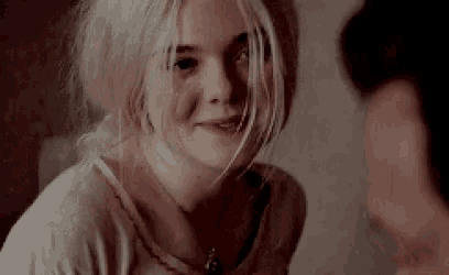 a woman with blonde hair is smiling and looking at the camera .