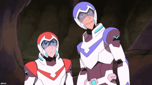 two cartoon characters are standing next to each other in a cave .