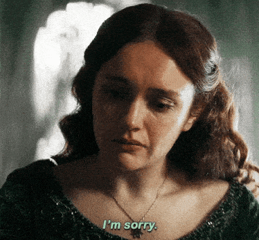 a woman wearing a green top and a necklace says i 'm sorry