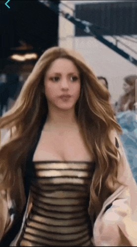 a woman with long hair is wearing a black and gold striped dress