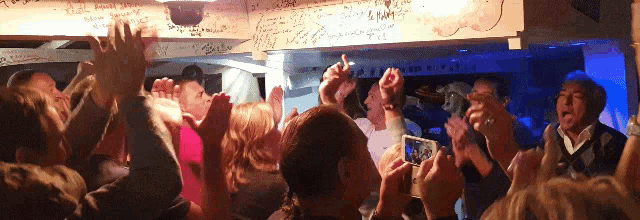 a crowd of people with their hands in the air and a sign that says ' i love you '
