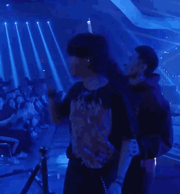 a person wearing a shirt that says ' nirvana ' on it stands in front of a crowd