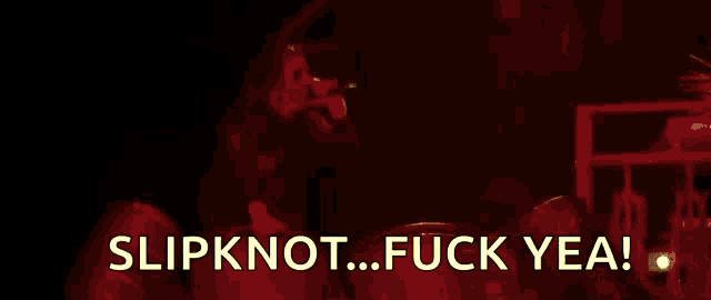 a man is standing in front of a fire with the words slipknot fuck yea