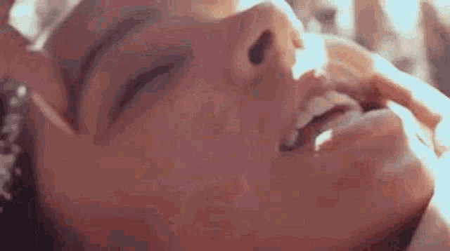a close up of a woman 's face with her mouth open .