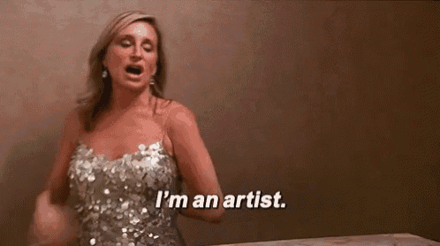 a woman in a silver dress is screaming and saying `` i 'm an artist . ''