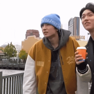 a man wearing a beanie that says " nishi " stands next to another man