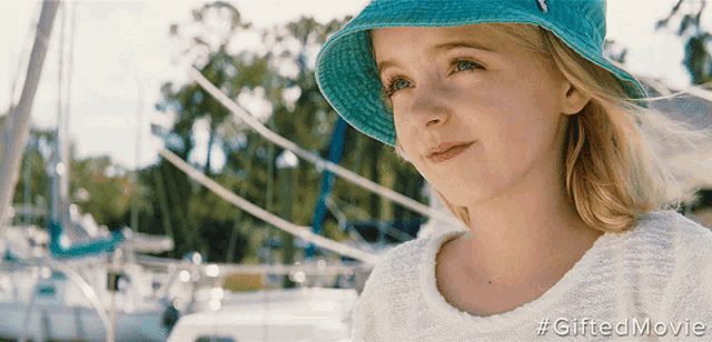 a little girl wearing a blue hat and a white shirt with the hashtag gifted movie