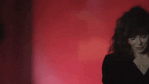 a woman is standing in front of a red wall .