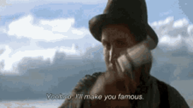 a man in a top hat is talking on a cell phone and saying yoohoo i 'll make you famous