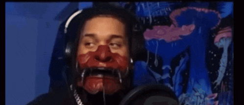 a man is wearing headphones and holding a red object in front of his face .