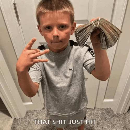 a young boy holding a stack of money with the words that shit just hit behind him
