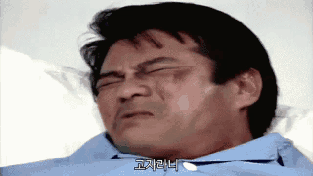 a man is laying in a hospital bed with a foreign language written on his face