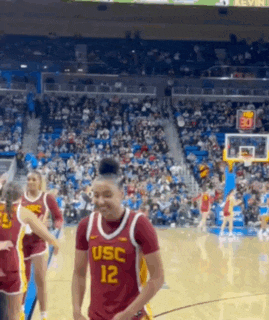 a woman wearing a usc jersey is smiling