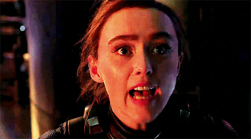 a woman is making a funny face with her mouth open in a dark room .
