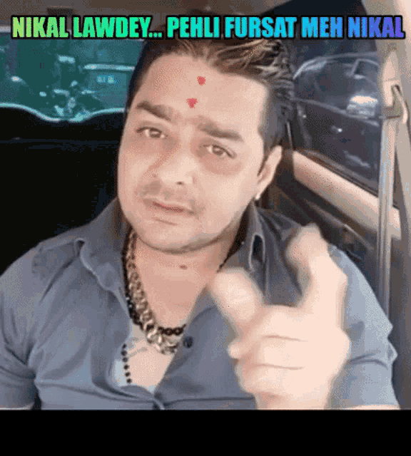 a man with a bindi on his forehead is giving a thumbs up