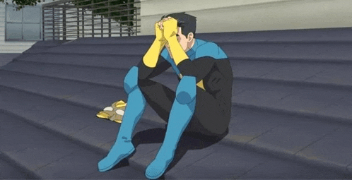 a man in a superhero costume is sitting on a set of stairs with his head in his hands .