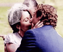 a man and a woman are kissing on their wedding day .