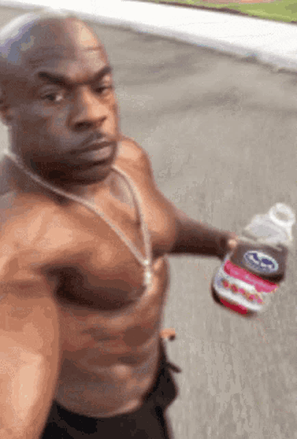 a man without a shirt is holding a bottle of diet coke