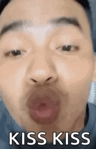 a close up of a man 's face with his mouth open and the words `` kiss kiss '' .