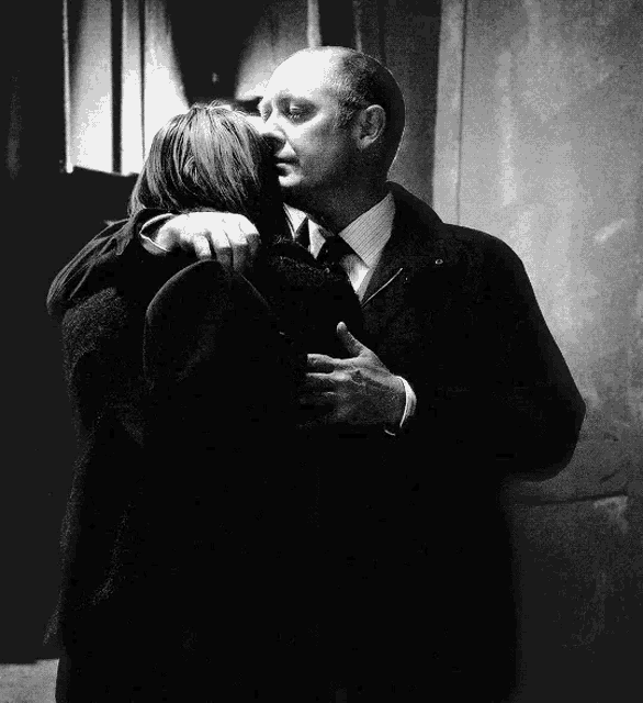 a man and a woman hugging each other in a black and white photo