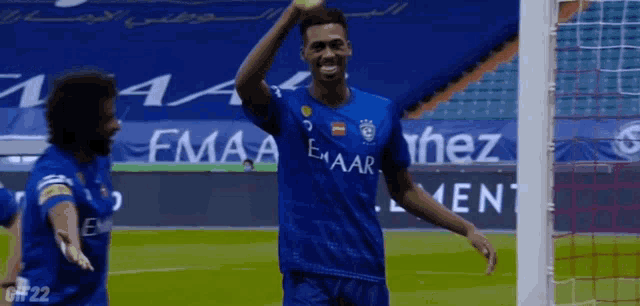 a soccer player wearing a blue jersey that says emaar