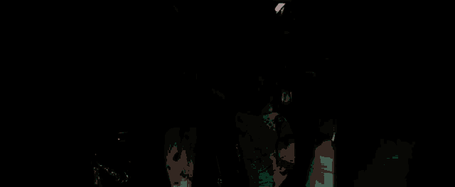 a group of men are standing next to each other in a dark room wearing sunglasses and jackets .