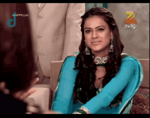 a woman in a blue dress is on a television screen with the number 2 in the corner