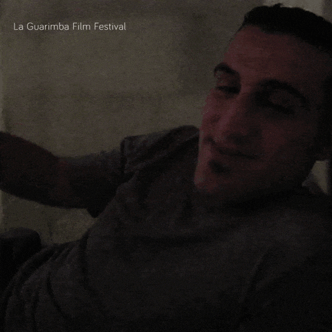 a man is smiling in a dark room with the words la guarimba film festival written above him