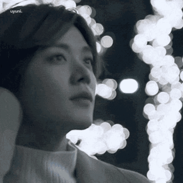a close up of a person 's face in front of a bunch of lights .